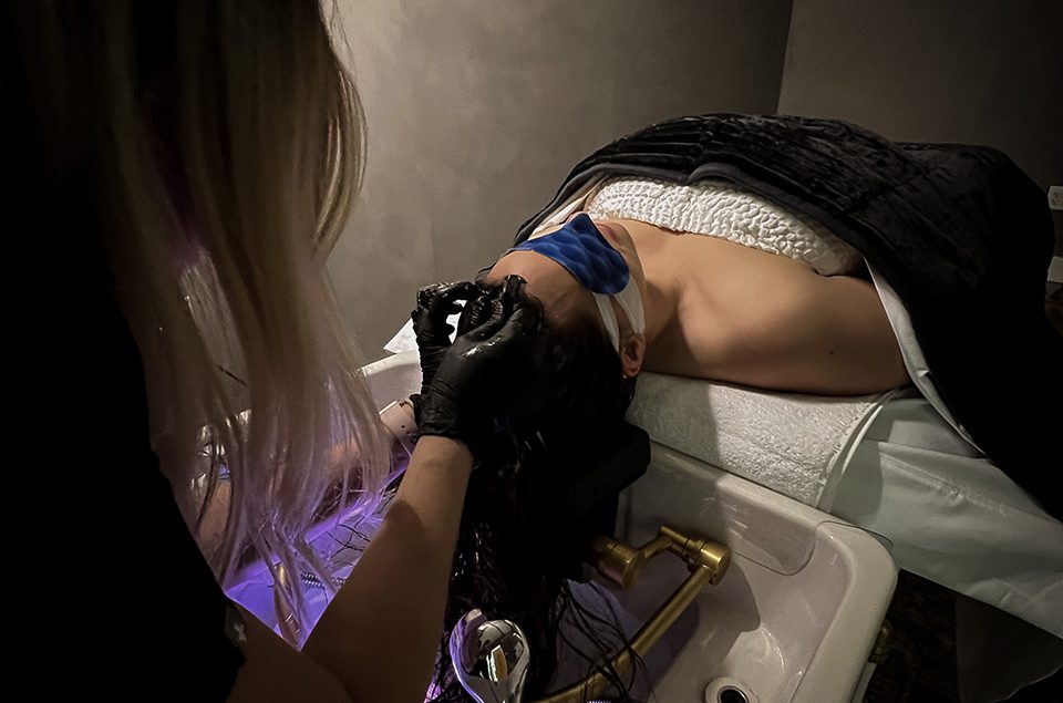 A client under a scalp treatment hood at 5 Birds